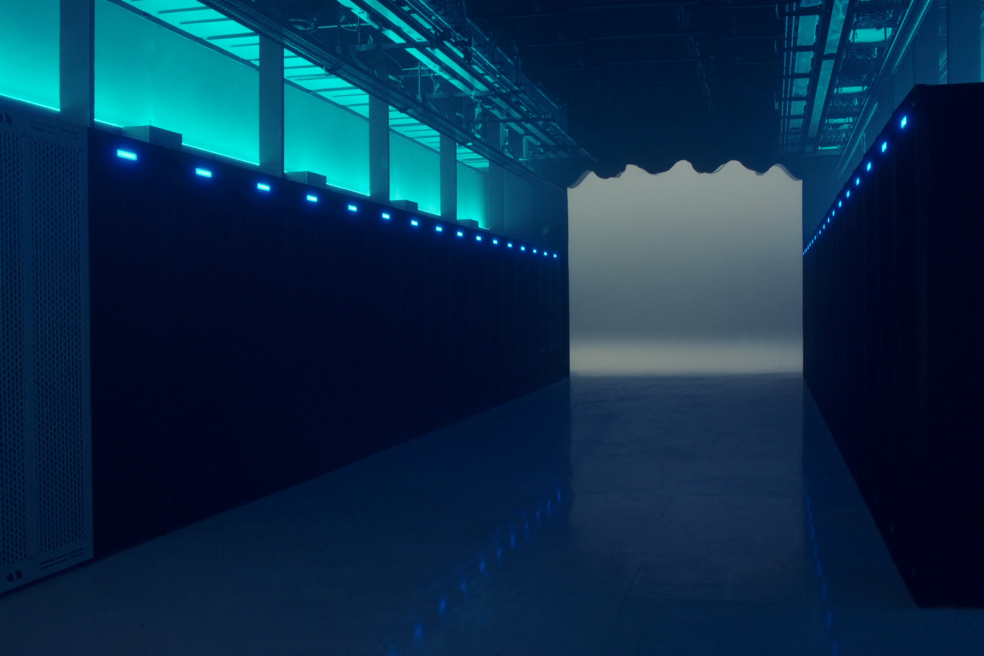 Modern data center aisle with cyan-lit racks.