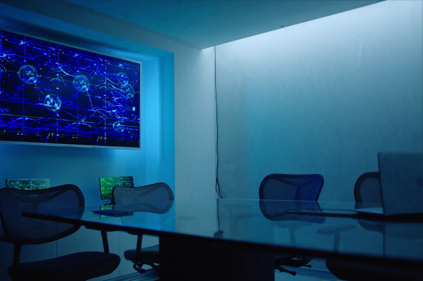 Senior engineers reviewing a network topology on a wall display in a modern operations center.